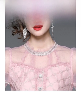 Détail de robe rose de luxe avec broderie dorée et décolleté en tulle transparent fini