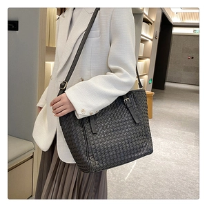 Detailansicht der schwarzen geflochtenen Ledertasche mit Textur getragen von einem Model