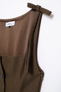 Detailed view of brown plaid pattern dress showing hidden zipper and shoulder strap details