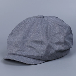 Close-up of gray cotton newsboy cap showing eight-panel stitch and twill texture