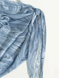 Close-up of light blue marble print fabric with drawstring detail on bikini set