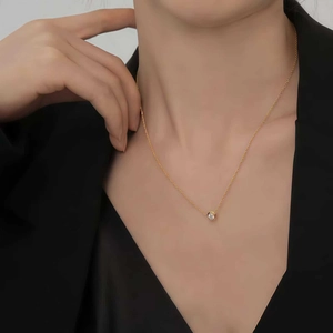 Primo piano di una collana in argento 925 placcato oro con ciondolo in gemma tonda