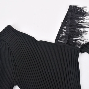 Detail of off-shoulder black knit top with textured ribs and feather trim decoration