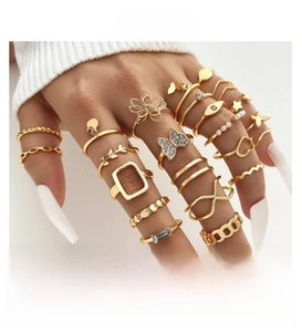 Detail of gold butterfly and pearl ring set on model hand with elegant bohemian design