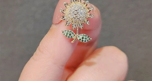 Détail macro d'une broche tournesol avec micro-pavage de zircons blancs et verts