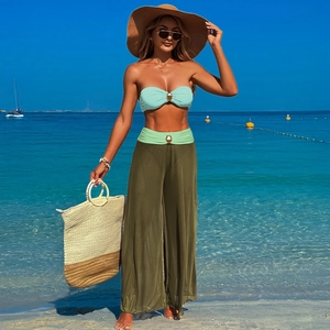 Close-up of beach bikini top and mesh trousers with golden decorative metal buckles