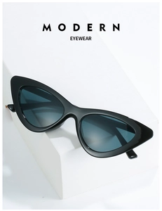Close-up of retro black cat-eye sunglasses displayed on minimalist white geometric pedestals