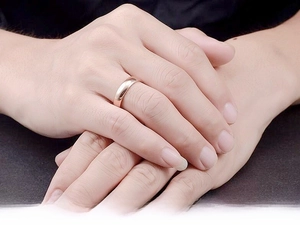 Close-up of minimalist rose gold titanium steel ring on a finger with smooth finish