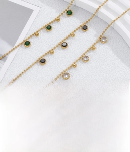 Vue détaillée d'un bracelet en acier titane doré avec zircons verts et noirs