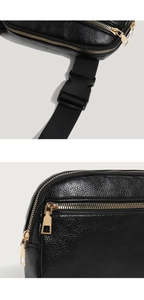 Detail of black lychee leather waist bag with gold zipper and plastic buckle
