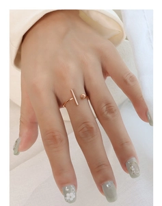 Detail of rose gold minimalist T-shaped open ring featuring a cylinder bar and ball design