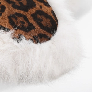 Macro detail of leopard print faux fur material with white plush trim on a winter hat