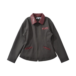 Close-up of contrast brown leather collar and chest pocket on dark grey zip-up jacket