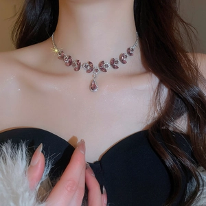 Close-up of elegant floral necklace with purple gemstones and crystals on a model