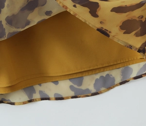 Détail du tissu mousseline à imprimé léopard avec doublure jaune et coutures d'ourlet fines