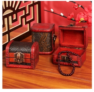 Close-up of three vintage red-brown wooden jewelry boxes with metal locks on a table