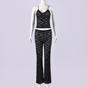 Detalle de textura de encaje floral en conjunto de top negro y pantalón campana