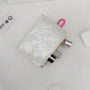 Close-up of quilted satin coin purse with bow embroidery and pink pull tab