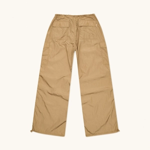 Detailed close-up of khaki wide-leg cargo pants with drawstring hems and textured fabric