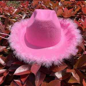 Detalle del borde de plumas suaves y el fieltro rosa brillante de este sombrero vaquero oeste