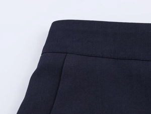 Detail of navy blue twill fabric waistline and precision stitching on the suit trousers
