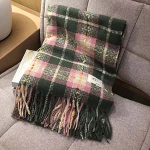 Green and pink plaid checkered scarf with tassels on sofa, soft cashmere-like feel