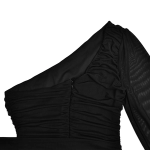 Détail de robe noire à une épaule avec manche en mesh et texture en tissu froncé