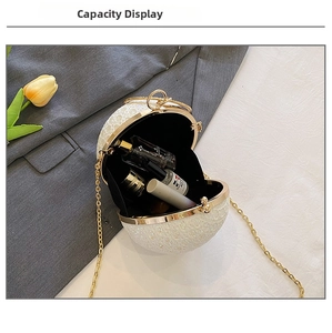 Detail showing capacity of spherical glitter clutch bag with golden chain and accessories
