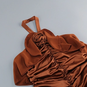 Detail of caramel halter dress featuring a 3D rose flower and ruffled satin neckline