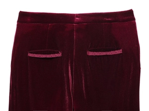 Macro shot of dark burgundy velvet trousers back waist featuring dual welt pocket details