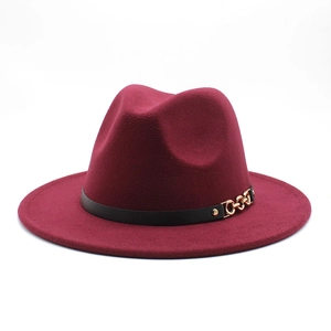 Close-up of maroon wool fedora hat with black leather strap and gold chain detail