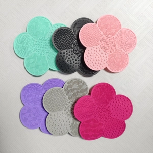 Overhead view of multi-color flower-shaped silicone makeup brush cleaning pads with textures