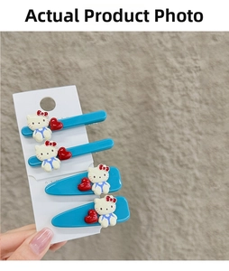 Detailansicht von vier blauen Hello Kitty Haarklammern mit roten Herzen auf Karte