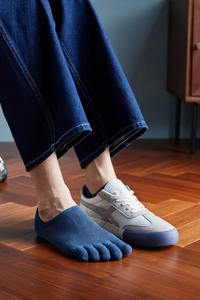 Detail of dark blue five-toe invisible socks showing separate toe design in sneakers