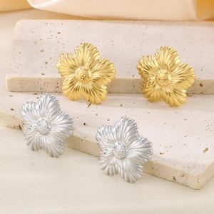 Dettaglio macro di orecchini a girasole con petali testurizzati in oro e argento