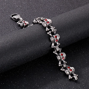 Close-up of gothic stainless steel skull bracelet with sparkling red crystal eyes