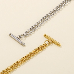 Detail of silver and gold stainless steel double-row chains with OT toggle clasp closure