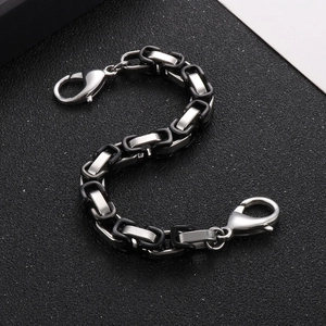 Detailed view of silver stainless steel curb chain with black decorative accents