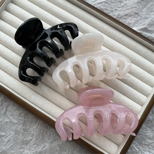 Three-piece jelly colored shark hair claws in black, cream, and pink on a jewelry tray