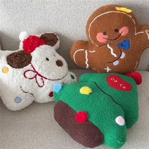 Detail of plush Christmas pillows featuring a dog, gingerbread man, and embroidered tree