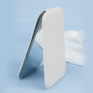Close-up of portable folding vanity mirror with white PU leather cover on blue background