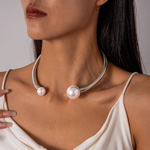 Close-up of a silver geometric choker with elegant faux pearls for a minimalist look