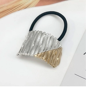 Close-up of gold and silver plated alloy hair tie with pleated texture on white backdrop