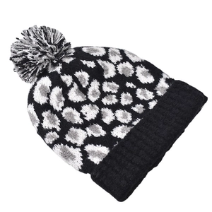 Close-up of leopard pattern knit hat with black cuff and tri-color fuzzy pom-pom top