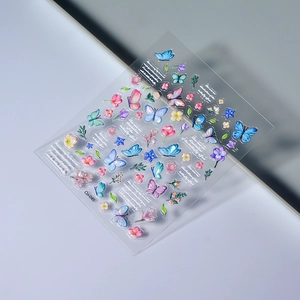 Macro detail of 5D embossed nail stickers featuring colorful butterflies and flowers