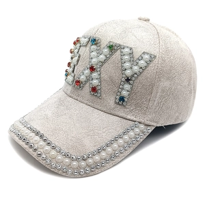Détails des strass et perles brodés sur une casquette de baseball en daim beige élégante