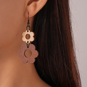 Detail of bohemian hollow wooden flower earrings on model highlighting the natural texture