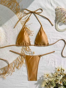 Flat lay of metallic gold bikini with straw hat and seashells for beach vacation