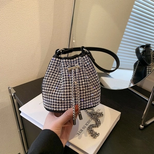 Elegant silver rhinestone bucket bag with black leather handle and metallic chain strap