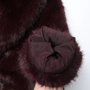 Dettaglio del cappotto di pelliccia sintetica bordeaux che mostra il polsino e la fodera interna